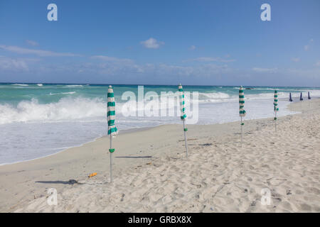 Einsamen weißen Sandstrand, Sonnenschirme, Überspannungsschutz, blauen Himmel und weiße Wolken Stockfoto