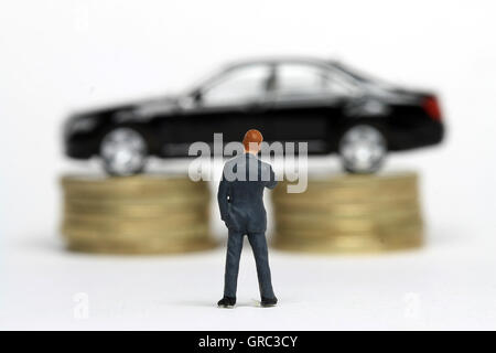 Miniatur-Geschäftsmann mit Limousine auf Münzen Stockfoto