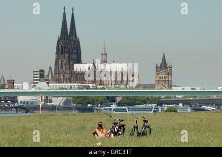 Frauen sitzen am Ufer des Rheins In Köln Stockfoto