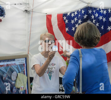 Festival-Goer wählt Hillary Clinton Kampagne Taste von Donna Oleston demokratische Partei stand, Boulder Heimatstadt Festival statt Stockfoto