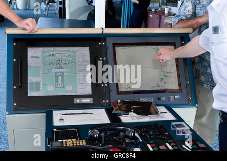 Officer Explaning Navigationshilfen für Passagiere auf Kreuzfahrt Schiff Brücke. Stockfoto