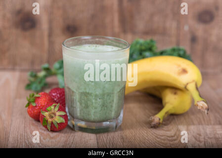 Grüner Smoothie-Shake mit Bananen, Erdbeeren und Grünkohl Stockfoto