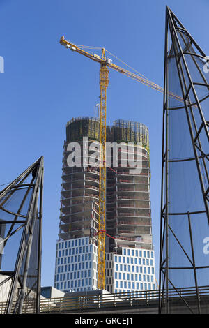 Wolkenkratzer im Bau mit hohen Kran und Metallbau im Vordergrund Stockfoto