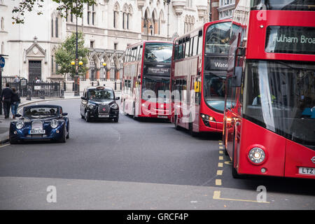 London-rote Doppeldecker-Busse, schwarzen Taxis Taxis und Morgan Sports Car. Verkehr im Zentrum von London durch den Strang. Stockfoto