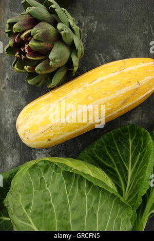 Draufsicht der frisch geernteten britische gewachsenen Artischocke, gelbe Knochenmark und Kohl Schiefer Hintergrund, England UK Stockfoto