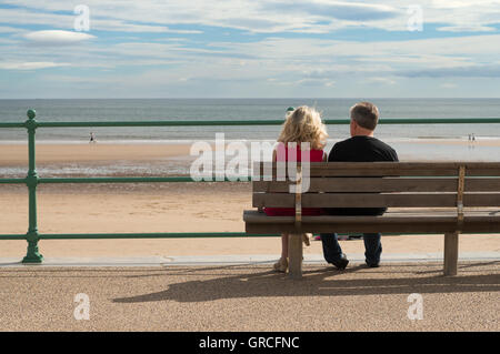 Paar setzte sich mit Blick auf die Nordsee bei Seaburn, Sunderland, Nord-Ost-England, UK Stockfoto