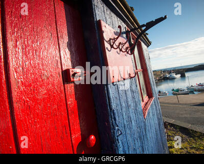 Rote und blaue Hütte im kleinen Fischerdorf Dorf von St. Abbs, Berwickshire schottischen Grenzen UK Stockfoto