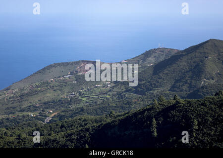 Blick von einem Aussichtspunkt über bewaldete Hügel bis in den Atlantischen Ozean Nd blauen Himmel. Nordwesten der Kanarischen Insel La Palma Stockfoto