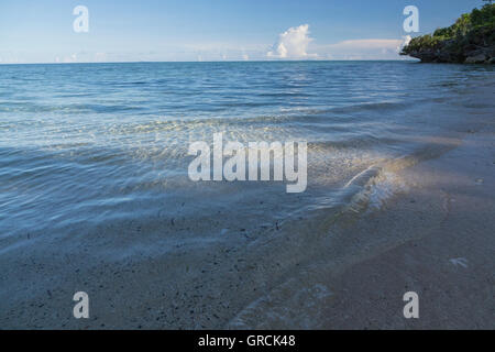 Kleine Wellen In sanftes Licht waschen an Land den Sandstrand von Selayar Stockfoto