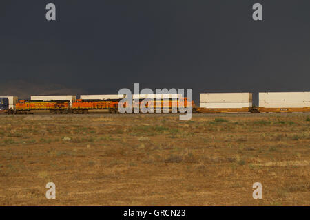 Güterzug durch Wüste mit stürmischen Himmel bewegen. Nevada, USA Stockfoto