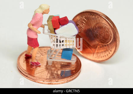 Frau und volle Shopping Cart auf eins und zwei-Euro-Cent-Münzen Stockfoto