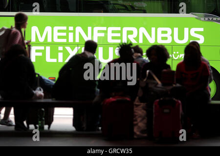 Long Distance Bus Meinfernbus mit Silhouetten des Wartens Reisende In München Stockfoto