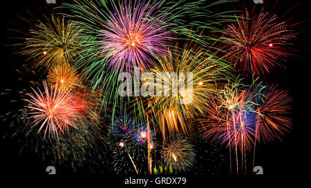 Buntes Feuerwerk Feier am dunklen Nacht Himmelshintergrund. Schönes Feuerwerk am klaren Nachthimmel. Stockfoto