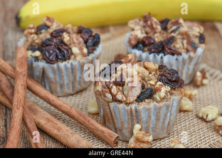 Muffins mit Haferflocken, Zimt, Rosinen und Bananen in einem rustikalen Rahmen Stockfoto