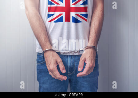 Mann mit gefesselten Händen tragen Hemd mit Großbritannien Flagge verhaftet. Nicht erkennbare männliche Person in Jeans mit Handschellen hielt ich Stockfoto