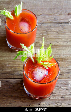 Tomatensaft mit Sellerie, Gewürzen, Salz und Eis in Gläser Teil. Bloody Mary cocktail. Stockfoto