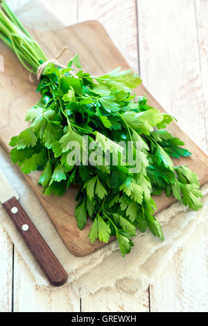 Bio Italienische Petersilie Closeup auf rustikalen Holztisch, gesunde vegetarische Ernährung Stockfoto