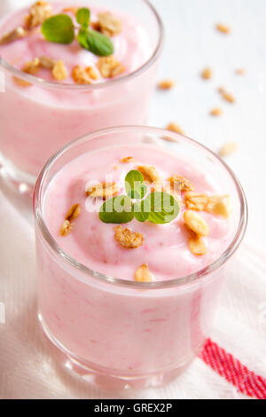 Hausgemachte Bio-Erdbeer-Joghurt mit Müsli und Minze in Teil Gläser hautnah Stockfoto