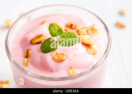 Hausgemachte Bio-Erdbeer-Joghurt mit Müsli und Minze in Teil Gläser hautnah Stockfoto