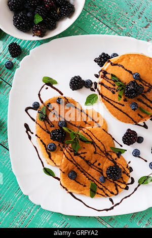 Leckere Pfannkuchen mit Brombeeren und Schokolade. Ansicht von oben Stockfoto