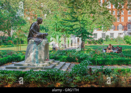 Tavistock Square in London, entspannen, Leute in der Nähe eine Statue von Mahatma Gandhi in Tavistock Square, Bloomsbury, UK. Stockfoto