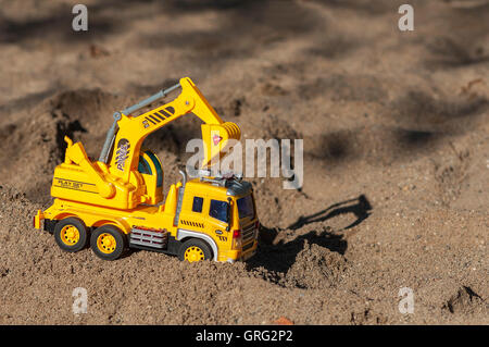 Spielzeug Bagger im Sand. Kinderspielzeug Stockfoto