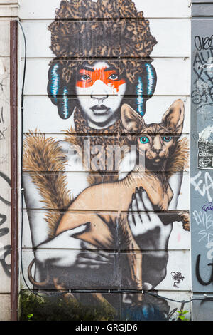 Frau mit Katze Wandbild Graffiti an der Wand an der Brick Lane, Shoreditch, London im September Stockfoto