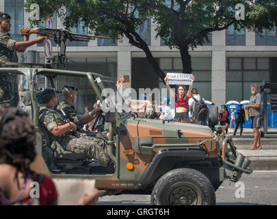 Rio de Janeiro, Rio de Janeiro, Brasilien. 07. September 2016. Frau hält einen Banner gegen brasilianische Präsident Michel Temer, als eine Gruppe von drei schwer bewaffneten Soldaten an und fahren durch auf ihrem gepanzerten Fahrzeug. Dies wurde bei der Brasilianischen Unabhängigkeit Parade in Rio de Janeiro. Credit: Ellen Pabst dos Reis/Alamy leben Nachrichten Stockfoto