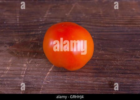 Frisch gepflückt ganz rote, reife Tomaten auf dem hölzernen Hintergrund Stockfoto