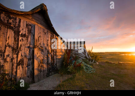 Umgedrehten Angelboote/Fischerboote am Strand bei Sonnenaufgang, Lindisfarne Holy Island Northumberland UK Stockfoto