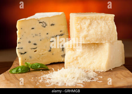 Stücke von Blue Cheese und Parmesan auf einem Holzbrett wird geschnitten mit Käsemesser mit Gewürzen auf einem hölzernen restaurant Stockfoto