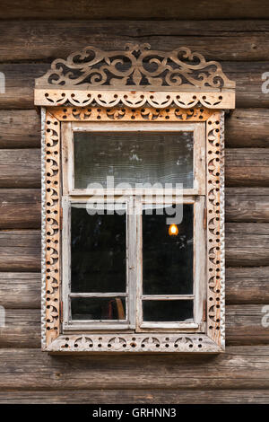 Die traditionelle ländliche russische Architektur Details. Fenster mit geschnitzten Holzrahmen in Mauer aus groben Protokolle Stockfoto