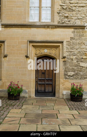 Alte Holztür in einem Innenhof am Trinity College in Oxford, UK Stockfoto