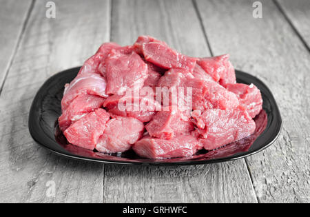 Rohes Rindfleisch Fleisch auf einem Teller und grau Holz Hintergrund Stockfoto