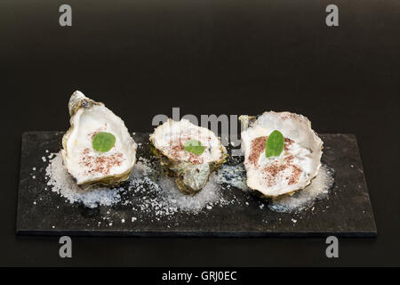 Austern mit Meeres-Schaum Reduktion auf einem Bett aus Salz Stockfoto