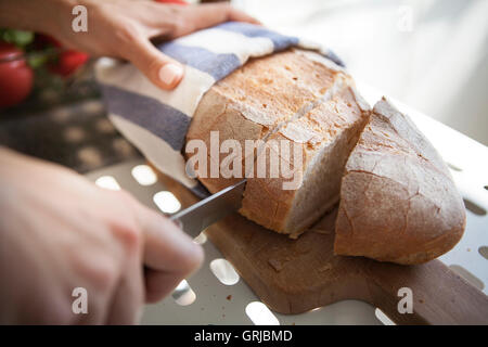 Baker, Kleie Brot schneiden, auf ein Schneidebrett Stockfoto