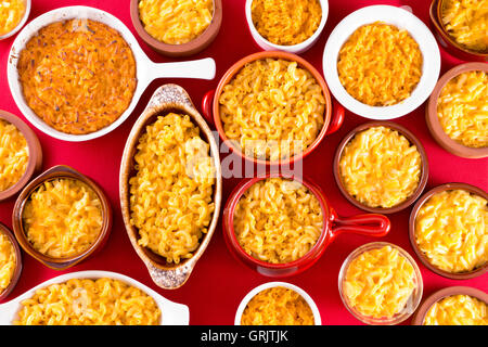 Käse-Makkaroni, die konzeptionell auf rote Baumwolle Tischdecke in verschiedene Arten von Schüsseln serviert Stockfoto