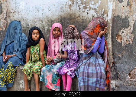 Stone Town, Tansania - 10. Januar 2016: Kinder in traditionelle muslimische Kleidung, sitzen auf der Straße von Stone Town. Stockfoto