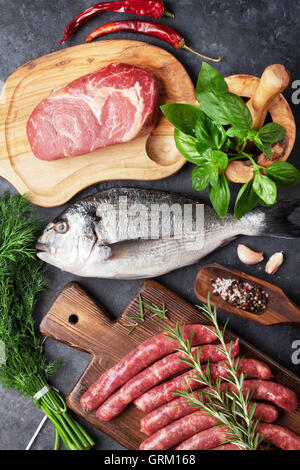 Wurst, Fisch, Fleisch und Zutaten kochen. Draufsicht auf Steintisch Stockfoto