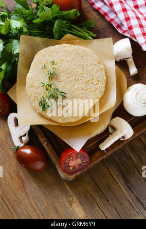 Frisches rohes Hühnchen Lammkoteletts mit Kräutern und Gemüse auf einem Holzbrett Stockfoto