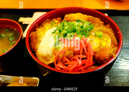 Eine Schüssel mit Katsudon gebratenes Paniertes Schweineschnitzel auf Reis mit Miso-Suppe serviert in einer japanischen Restaurant.NYC USA Stockfoto