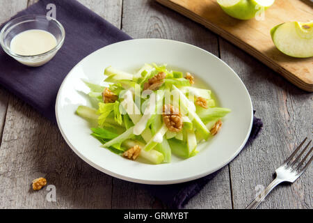 Waldorf-Salat mit grünem Apfel, Sellerie und Walnüssen über rustikale Holz Hintergrund Stockfoto