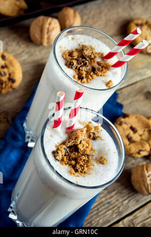 Hausgemachter Milchshake mit Schokolade-chips Cookies und Nüssen auf rustikalen Holztisch hautnah Stockfoto