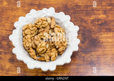 Frische Walnüsse in einer weißen Schüssel auf dem Tisch Stockfoto