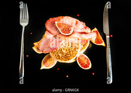 Brinner - Frühstück zum Abendessen. Ein Stapel von Fladenbrot mit Speck, Feigen und Ahornsirup auf schwarzem Schiefer Teller Stockfoto