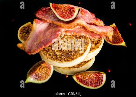 Brinner - Frühstück zum Abendessen. Ein Stapel von Fladenbrot mit Speck, Feigen und Ahornsirup auf schwarzem Schiefer Teller Stockfoto