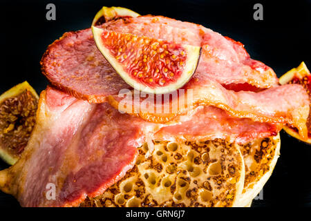 Brinner - Frühstück zum Abendessen. Ein Stapel von Fladenbrot mit Speck, Feigen und Ahornsirup auf schwarzem Schiefer Teller Stockfoto