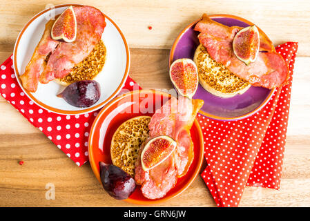 Brinner - Frühstück zum Abendessen. Ein Stapel von Fladenbrot mit Speck, Feigen und Ahornsirup auf Tablett aus Holz Stockfoto