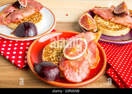 Brinner - Frühstück zum Abendessen. Ein Stapel von Fladenbrot mit Speck, Feigen und Ahornsirup auf Tablett aus Holz Stockfoto