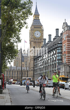 Radfahrer nutzen Londons neue getrennten Radweg am Victoria Embankment, an der Themse. Big Ben im Hintergrund. Stockfoto